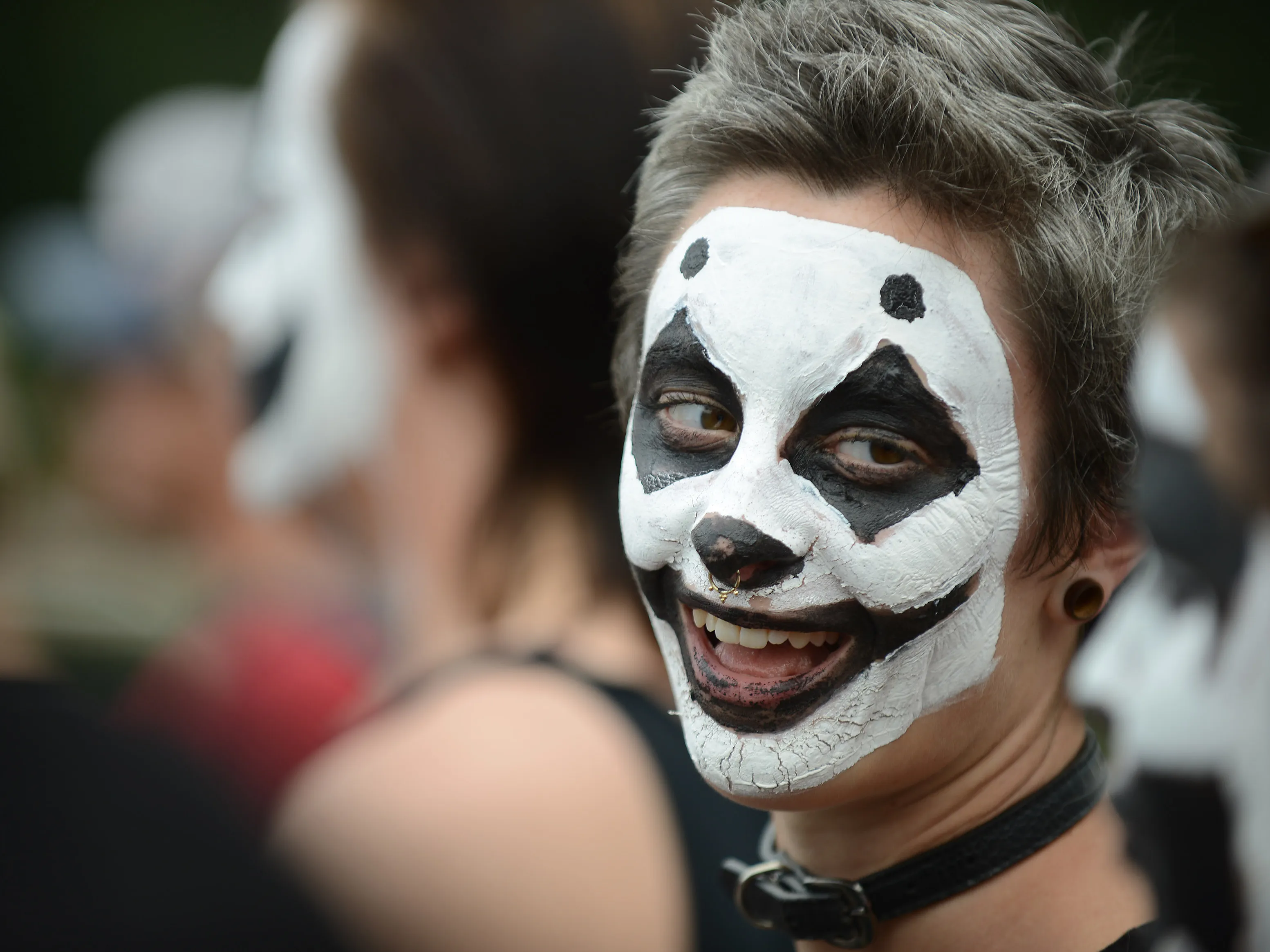 a happy juggalo looking slightly to the right at his friend, who is partially visible and blurry in the lower right corner of the image.webp