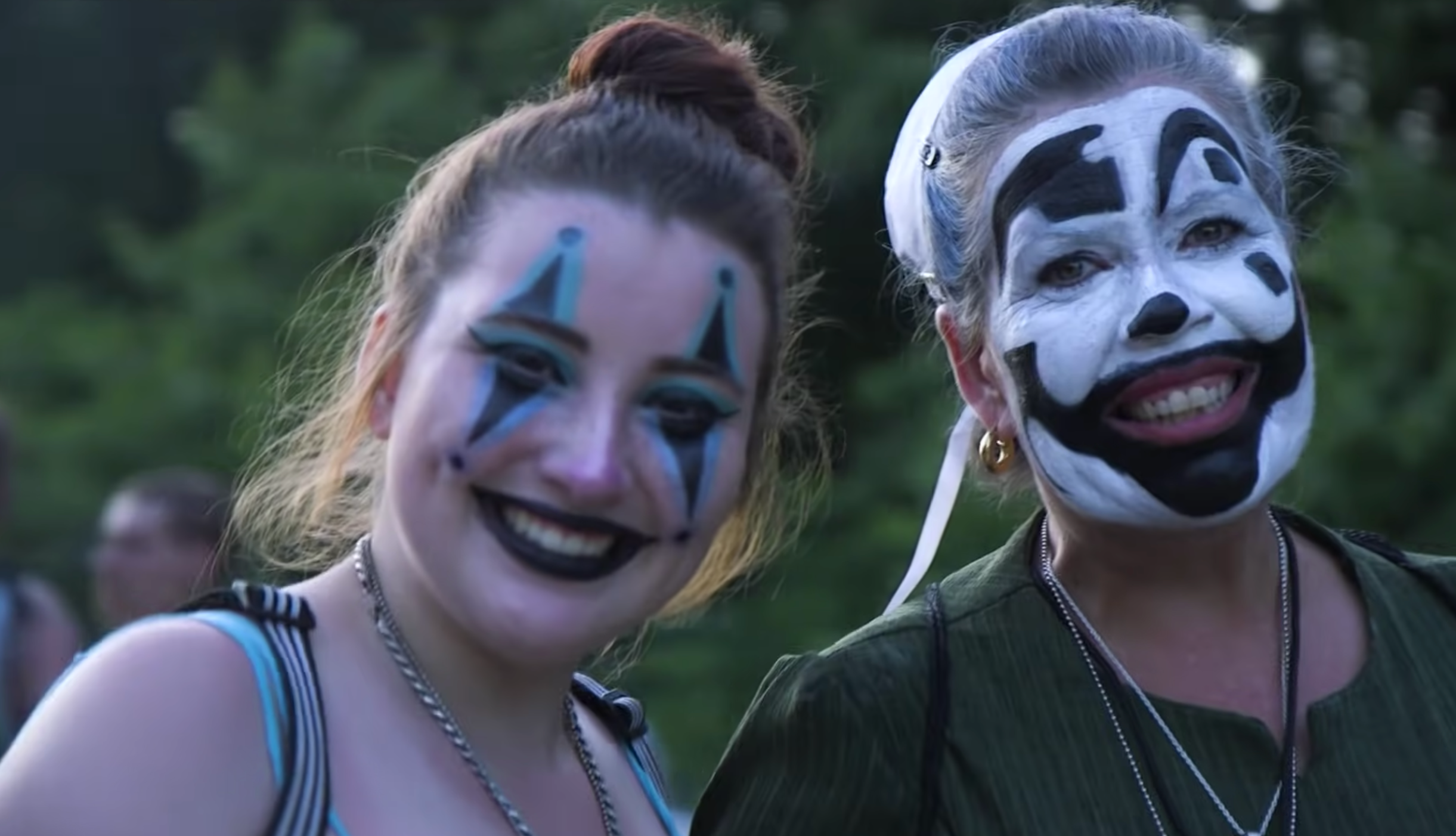 a juggalo woman and her daughter (on the left) in a professional bokeh photo, smiling for their portrait together.webp